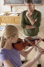 Teacher and teenage girl (14-15) playing violin. 
Photo : Rob Lewine