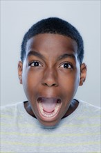 Portrait of teenage boy (14-15) screaming, studio shot. 
Photo: Rob Lewine