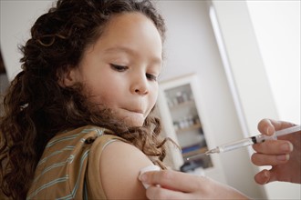 Girl (8-9) having vaccination. 
Photo : Rob Lewine