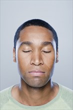 Portrait of young man with eyes closed, studio shot. 
Photo : Rob Lewine