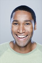 Portrait of smiling young man, studio shot. 
Photo : Rob Lewine