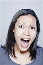 Portrait of screaming young woman, studio shot. 
Photo : Rob Lewine