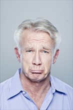 Portrait of senior man making sad face, studio shot. 
Photo : Rob Lewine