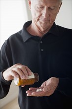 Senior man taking pills. 
Photo: Rob Lewine