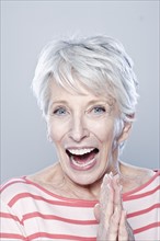 Portrait of laughing senior woman, studio shot. 
Photo : Rob Lewine