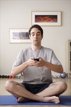 Young man meditating with mobile. 
Photo : Rob Lewine