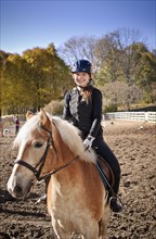 Canada, Ontario, Toronto, Portrait of teenage girl (16-17) riding on horse. 
Photo: Elena