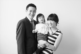 Portrait of young parents with baby girl (12-17 months). 
Photo : Jessica Peterson
