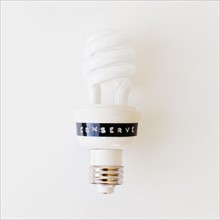 Energy efficient light bulb on white background, studio shot. 
Photo : Jessica Peterson