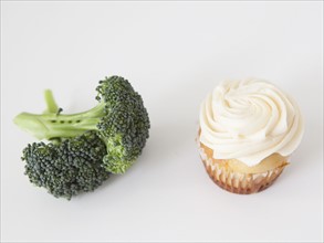 Broccoli and muffin on white background, studio shot. 
Photo: Jessica Peterson