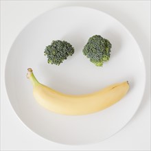 Fruit and vegetable smiling face on plate, studio shot. 
Photo: Jessica Peterson