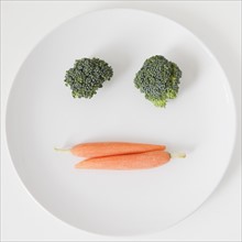 Vegetable face on plate, studio shot. 
Photo: Jessica Peterson