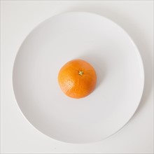 Orange on plate, studio shot. 
Photo: Jessica Peterson