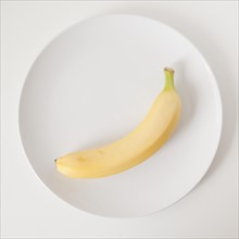 Banana on plate, studio shot. 
Photo : Jessica Peterson