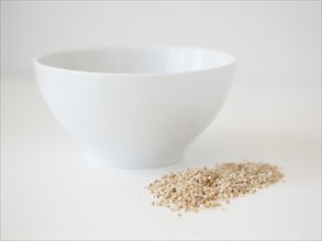 Bowl and wheat seed on white background, studio shot. 
Photo : Jessica Peterson