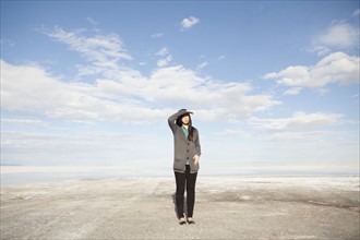 USA, Utah, Salt Lake City, Young woman standing on desert and looking away. 
Photo : Jessica