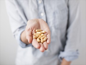 Woman showing handful of pills. 
Photo : Jessica Peterson