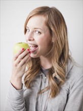 Portrait of attractive young woman holding green apple. 
Photo: Jessica Peterson
