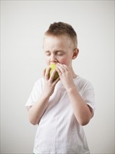 Portrait of toddler boy (2-3) devouring green apple. 
Photo : Jessica Peterson