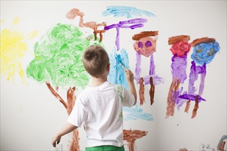 Toddler boy (2-3) painting on wall. 
Photo: Jessica Peterson