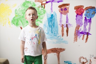 Toddler boy (2-3) standing in front of painted wall. 
Photo: Jessica Peterson
