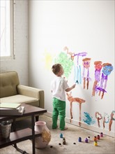 Toddler boy (2-3) painting on wall. 
Photo : Jessica Peterson
