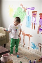 Toddler boy (2-3) painting on wall. 
Photo: Jessica Peterson