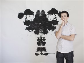 Man looking standing in front of complex shape painted on wall. 
Photo: Jessica Peterson