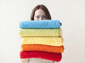 Young woman holding stack of towels. 
Photo: Jessica Peterson