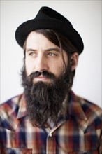 Profile of male character wearing long beard, hat and lumberjack shirt. 
Photo : Jessica Peterson