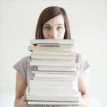 Young woman holding stack of books. 
Photo: Jessica Peterson