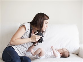 Mother photographing baby girl (2-5 months). 
Photo : Jessica Peterson
