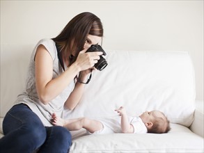 Mother photographing baby girl (2-5 months). 
Photo : Jessica Peterson