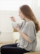 Happy young woman enjoying bowl of cornflakes. 
Photo : Jessica Peterson