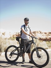 USA, Utah, Moab, Mid adult man posing with mountain bicycle in remote scenery. 
Photo : Jessica