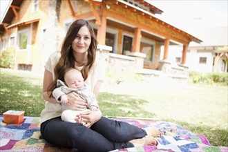 USA, Utah, Salt Lake City, Young mother with baby boy ( 2-5 months) lying on blanket. 
Photo :