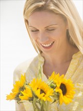 Woman holding sunflowers.