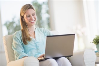 Woman listening to music from laptop.
