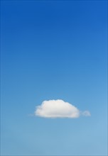 Blue sky with single cloud.