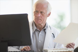 Male doctor working on computer.