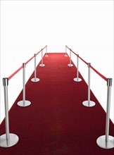 Studio shot of red carpet with stanchions and velvet rope.