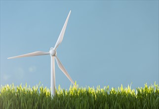 Model wind turbines in grass.