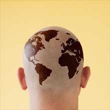 Back view of man with world map on shaved head.