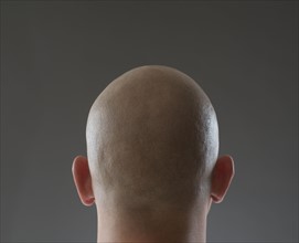 Back view of man with shaved head.