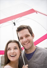 Couple under umbrella. Photo : Jamie Grill