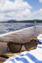 Close-up of sunglasses and towel on jetty. Photo : Daniel Grill