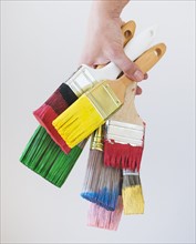 Bunch of paintbrushes held by male hand. Photo : Daniel Grill
