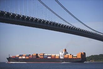 USA, New York City, Cargo ship passing by Verrazano Narrows Bridge. Photo: fotog