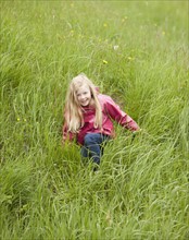 Girl playing among grass. Photo : Mike Kemp