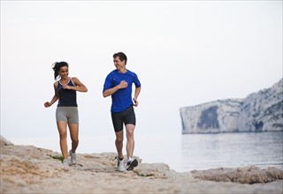 France, Marseille, Couple jogging by seaside. Photo: Mike Kemp